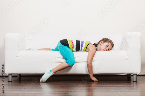 Tired exhausted lazy little girl kid lying on sofa photo