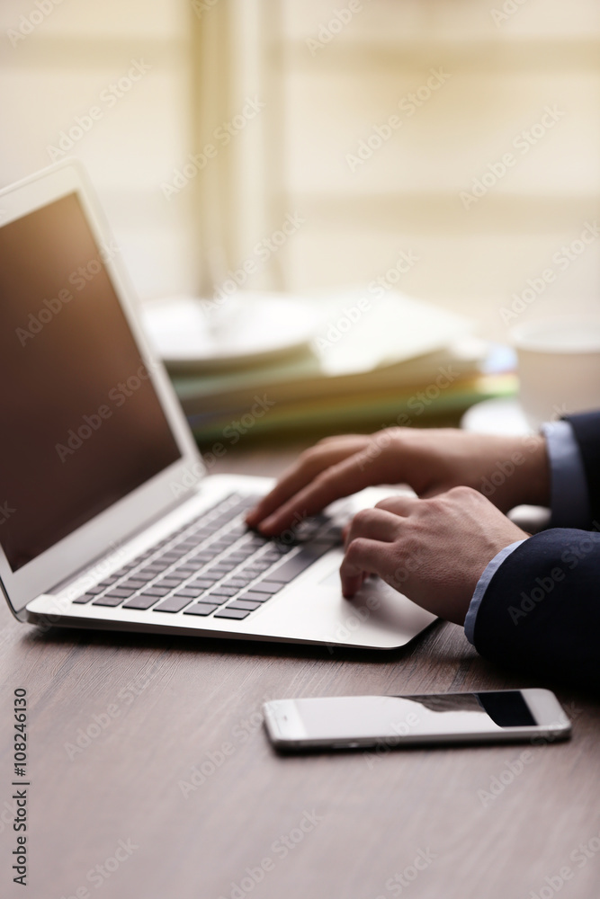 Man's hands using laptop at the table