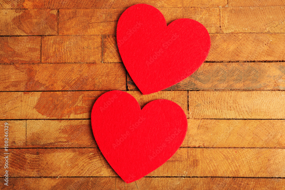 Red felt hearts on wooden background Red felt hearts on wooden background