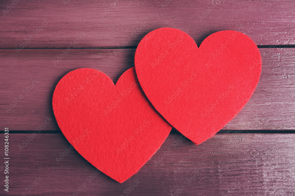 Red felt hearts on purple wooden background Red felt hearts on purple wooden background