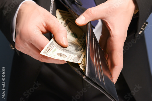 Man getting dollar banknotes out of purse