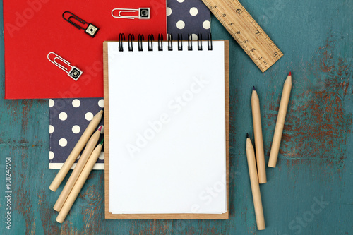 Office set with notebooks, colored pencils and ruler on blue wooden background