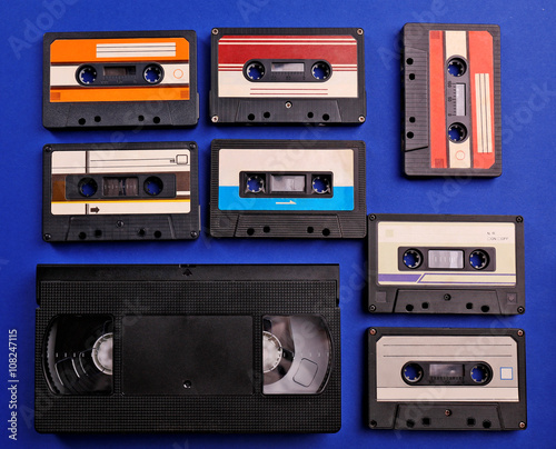 Set of old audio and video cassettes on blue background