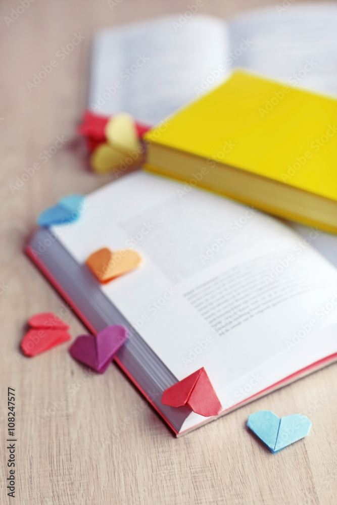 Books and heart shaped bookmarks on a light wooden background Books and heart shaped bookmarks on a light wooden background