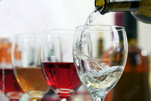 White wine pouring into glasses, closeup
