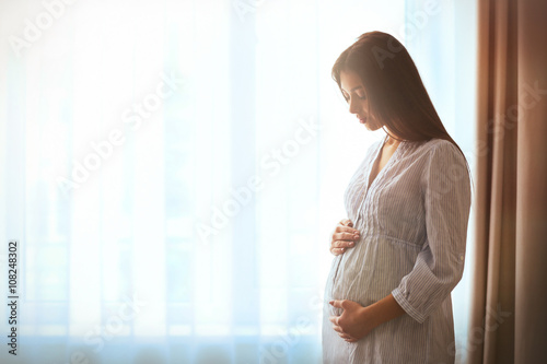 Pregnant woman standing nea...