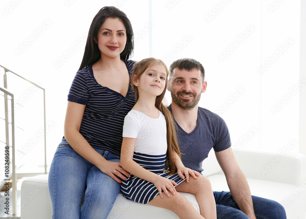 Parents and their daughter sitting on the couch