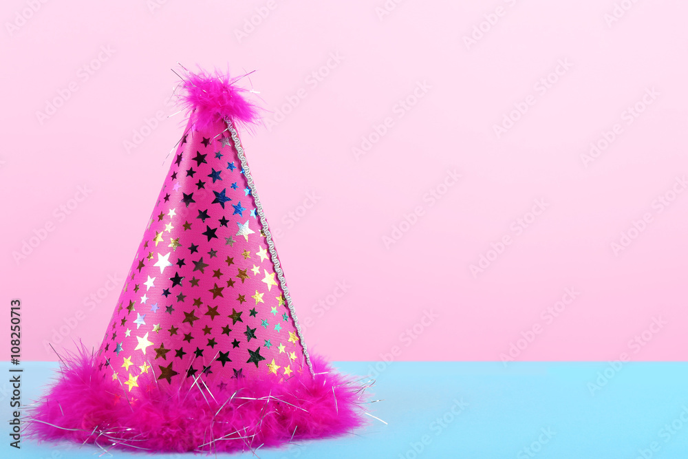 Pink party hat on pink background Pink party hat on pink background