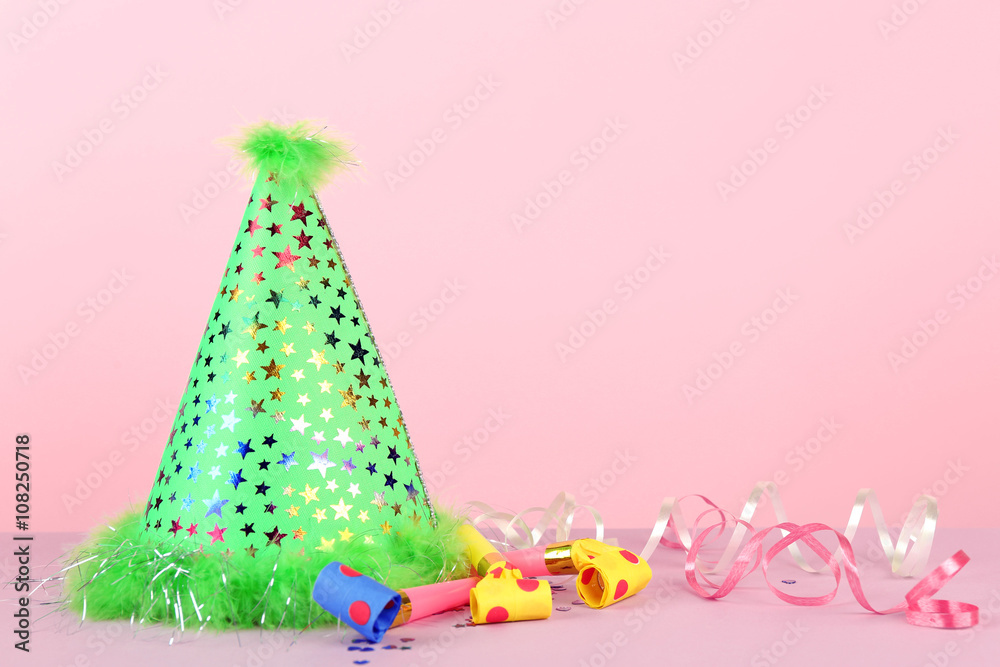 Green party hat on pink background