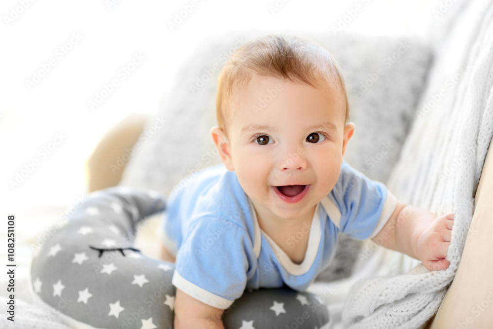Fototapeta premium Little baby boy crawling on a couch at home