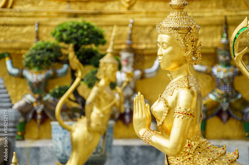 A Golden Kinnari statue in sawasdee action at the Temple of the Emerald Buddha (Wat Phra Kaew), Grand Palace , Bangkok, Thailand