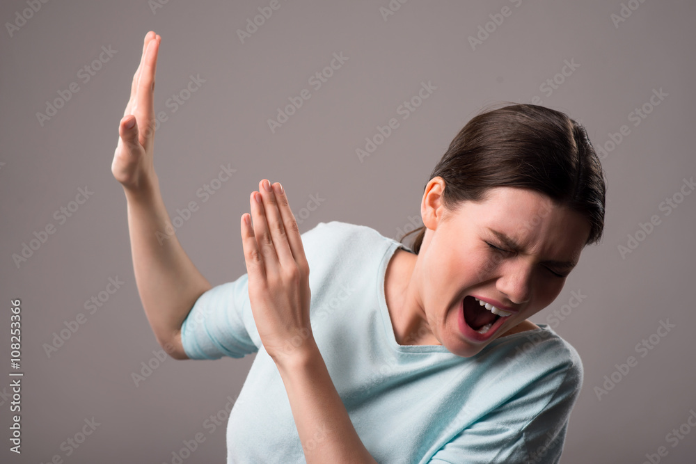 Cheerless girl standing isolated on grey background Cheerless girl standing isolated on grey background