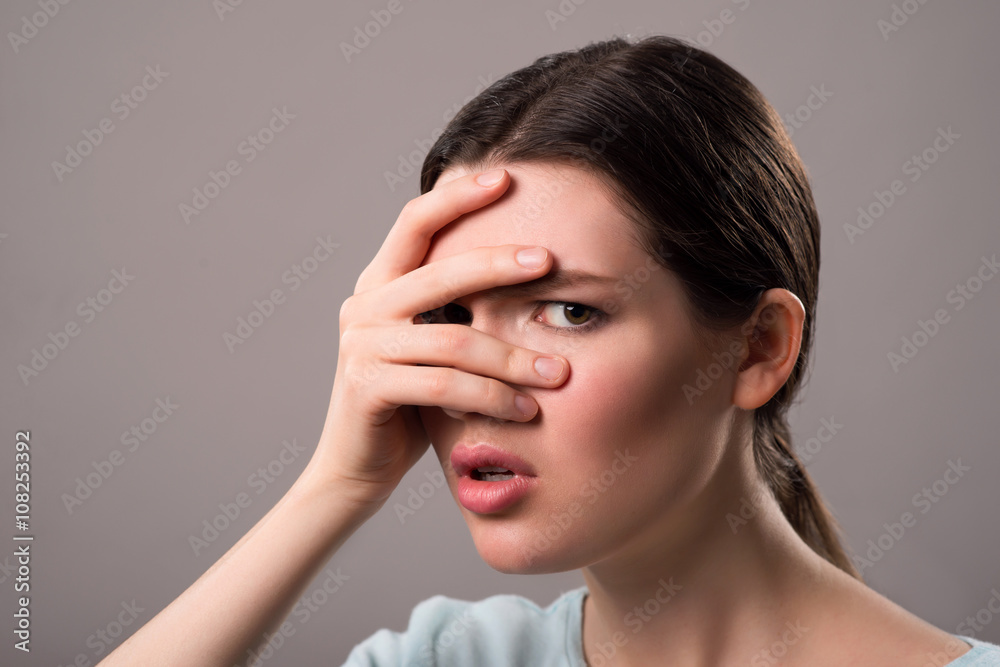 Gloomy girl standing isolated on grey background Gloomy girl standing isolated on grey background