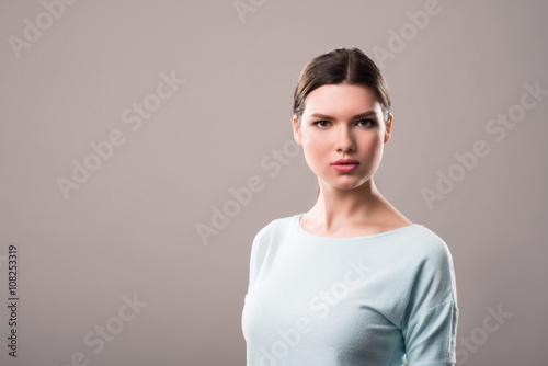 Pleasant girl standing isolated on grey background 