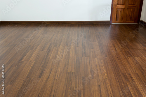 empty room, white mortar wall background and wood laminate floor