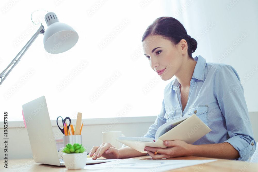Attractive young businesswoman is doing paperwork Attractive young businesswoman is doing paperwork