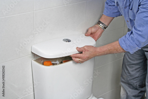 Photography Plumber repairing a toilet cistern