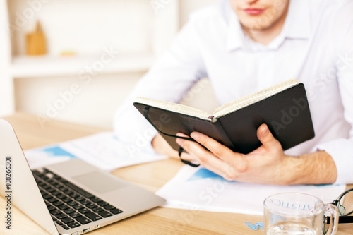 Man at desk with book