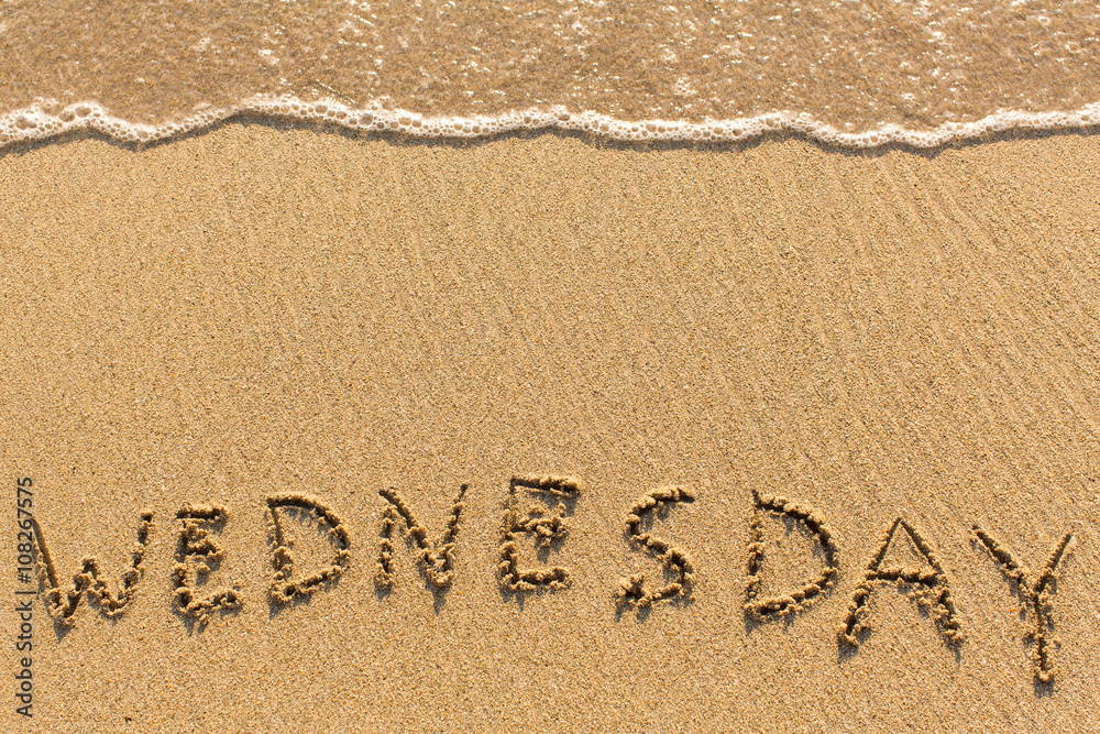 Fototapeta premium Wednesday - drawn of the hand on the beach sand, soft surf wave.