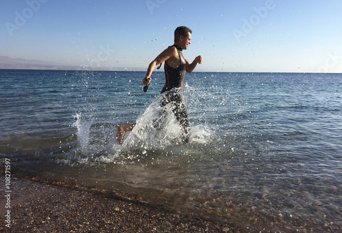 Professional triathlete practicing in open water. Plunge in sea.