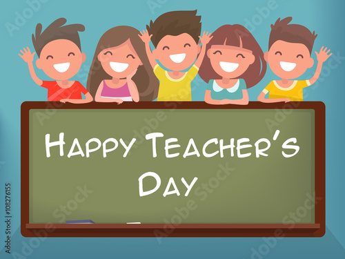 Little schoolchildren at the blackboard. Happy Teacher's Day photo
