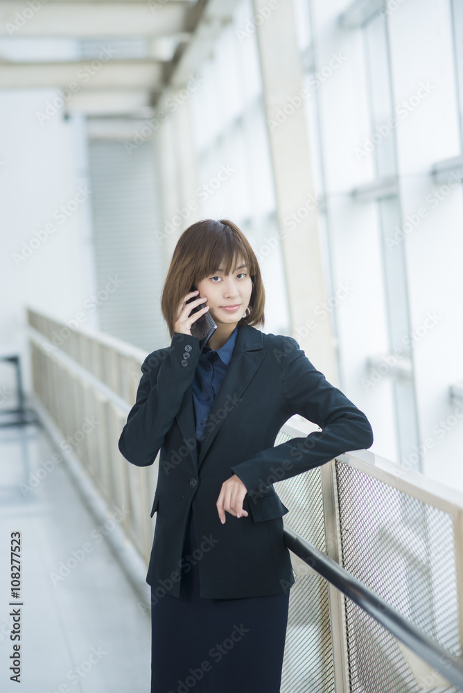 Attractive asian business woman using on smartphone outside Offi