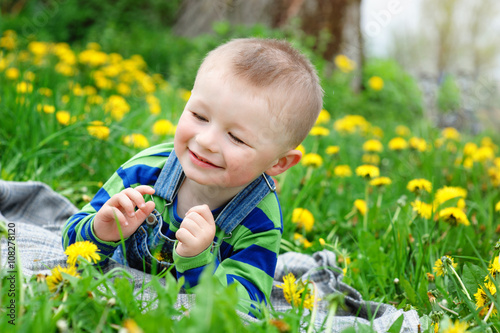 Happy little boy lying on meadow in spring © timonko