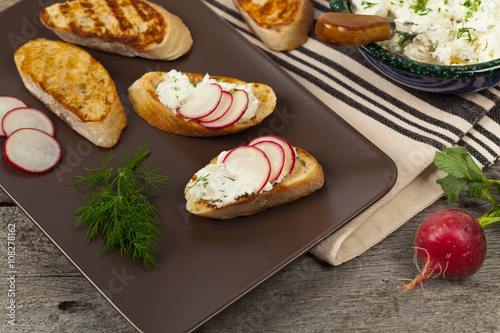 Bread Toasts with White Cheese and Radishes. Selective focus.