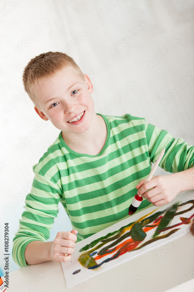 Slanted view of smiling boy with paint brush Slanted view of smiling boy with paint brush