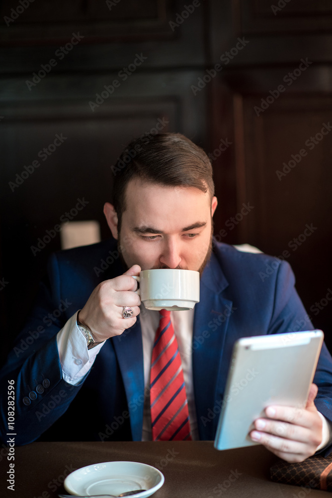 young successful businessman reads the news on tablet young successful businessman reads the news on tablet