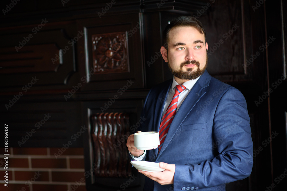 Rich successful handsome man in a suit drinking coffee Rich successful handsome man in a suit drinking coffee