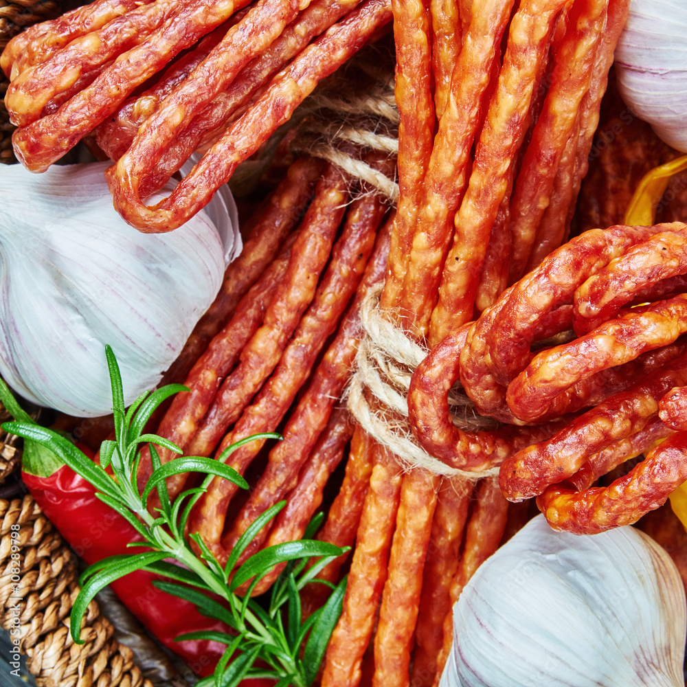 Cheese and chili snack stick sausages in a wooden basket