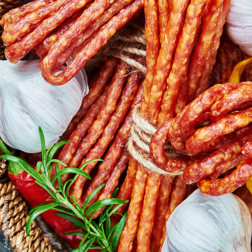 Cheese and chili snack stick sausages in a wooden basket