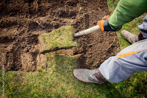 Man using spade for old lawn digging photo