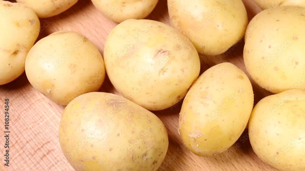 Organic potato on wooden background. Macro shot. Organic potato on wooden background. Macro shot.
