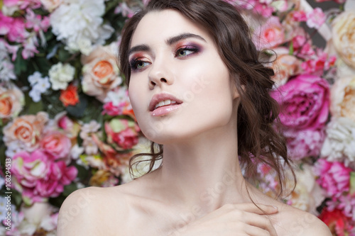 Portrait of  beautiful fashion girl  sweet  sensual. Beautiful makeup and messy romantic hairstyle. Flowers background. Green eyes. 