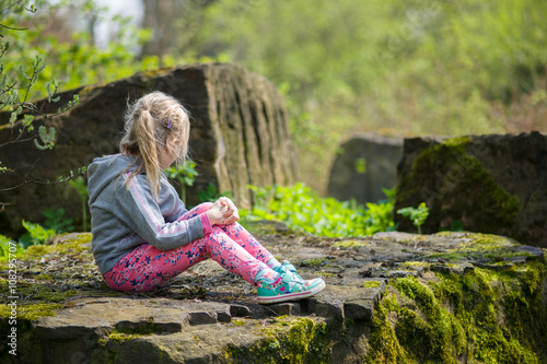 Dziewczynka na kamieniu w lesie