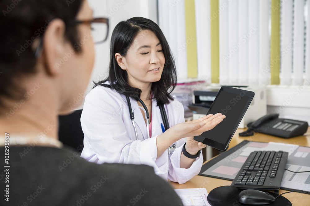 Smiling Doctor Showing Tablet Computer To Patient Smiling Doctor Showing Tablet Computer To Patient