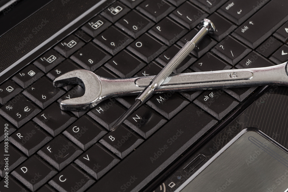 Fototapeta premium wrench tool and screwdrivers over a laptop