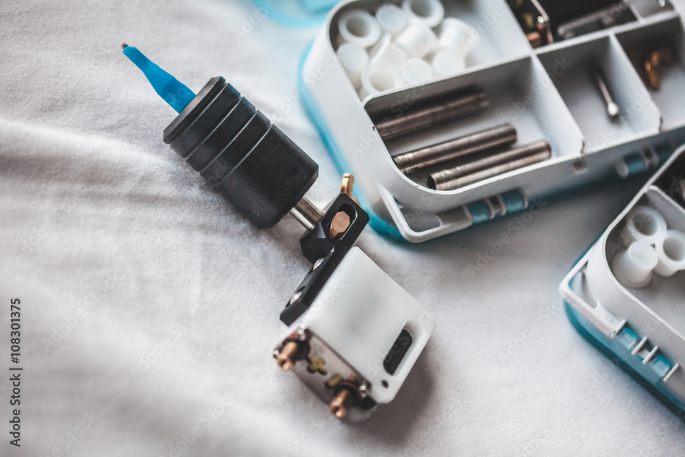 Tattoo artist preparing for work, details to tattoo machine and capsules for paints Tattoo artist preparing for work, details to tattoo machine and capsules for paints