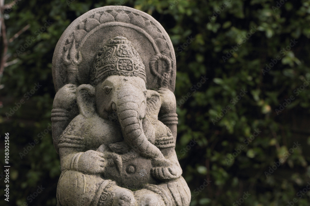 Hindu god lord Ganesh or Ganesha also known as Ganapati or Vinayaka depicted in a weathered garden ornament