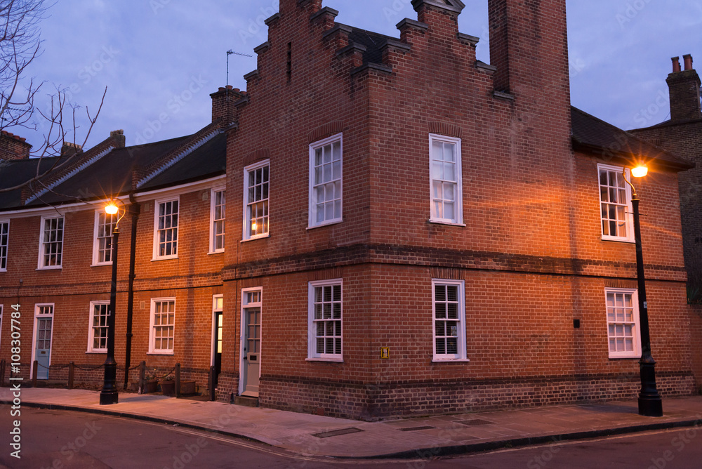 Restored Edwardian brick houses on a local road at night 