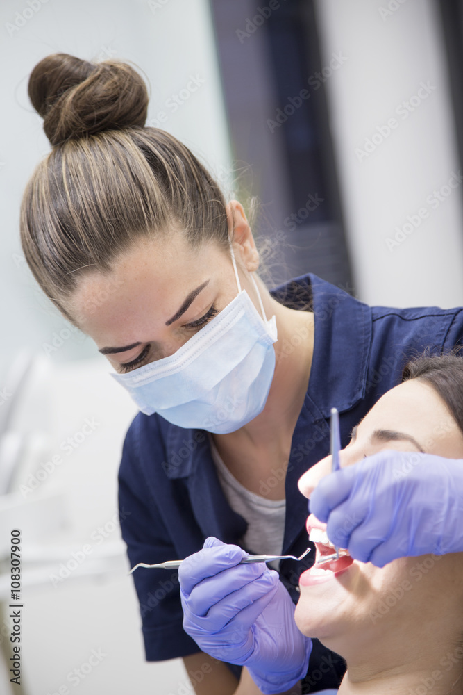 Naklejka premium At the dentist. Female dentist in action
