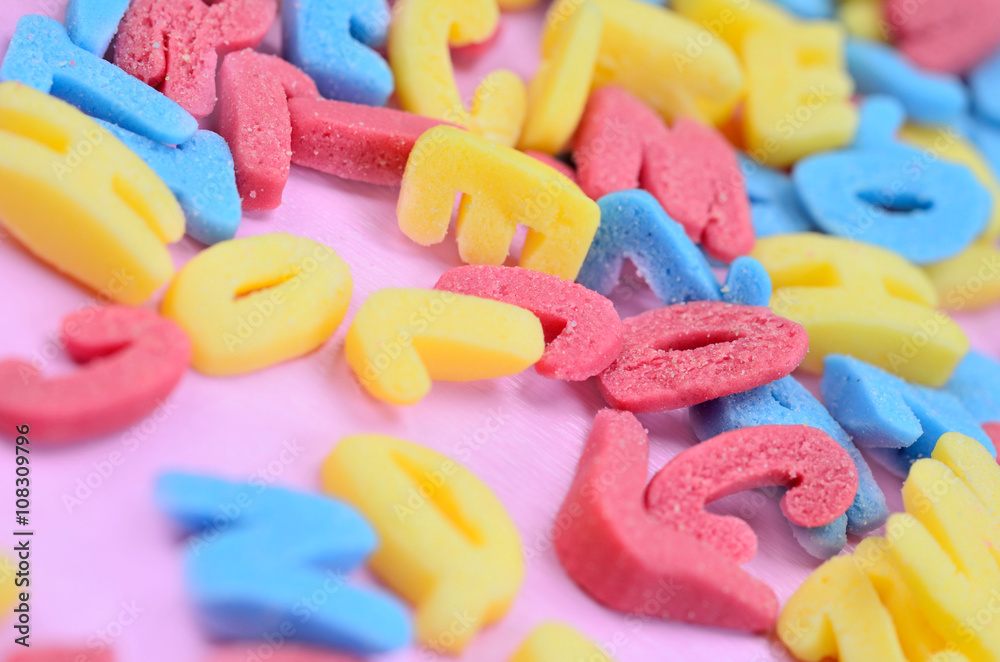 Many colorful letters on pink table Many colorful letters on pink table