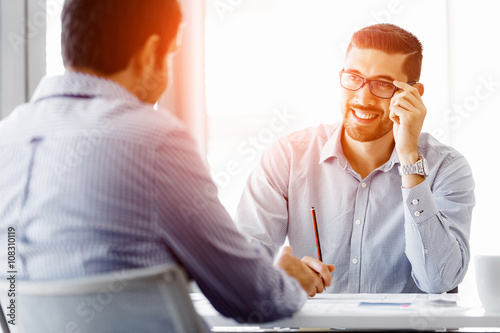 Attractive office worker sitting at desk photo