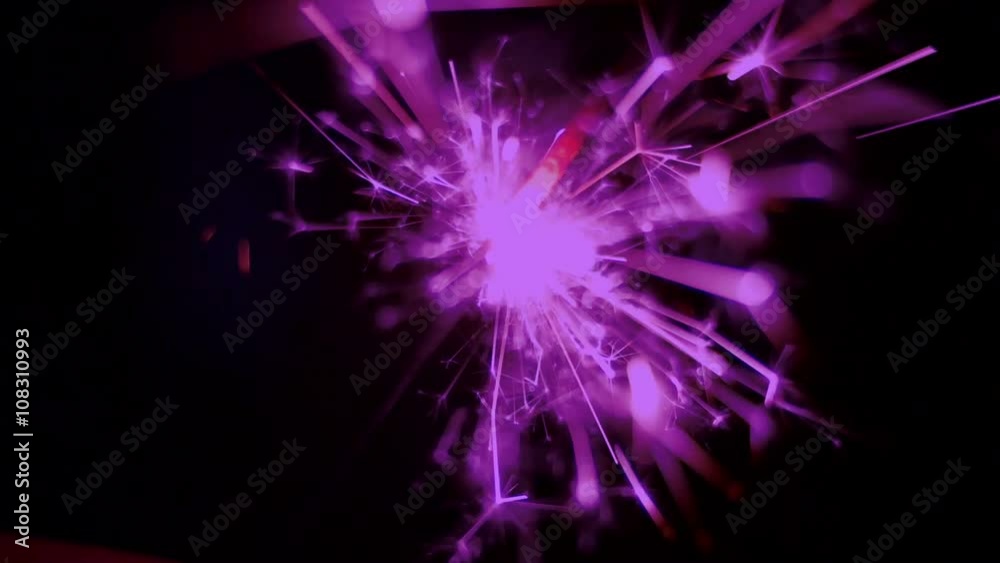Holiday sparkler burning in macro shot toned in vintage violet color. Holiday firework. 50 FPS Slow Motion. Defocused sparks Holiday sparkler burning in macro shot toned in vintage violet color. Holiday firework. 50 FPS Slow Motion. Defocused sparks