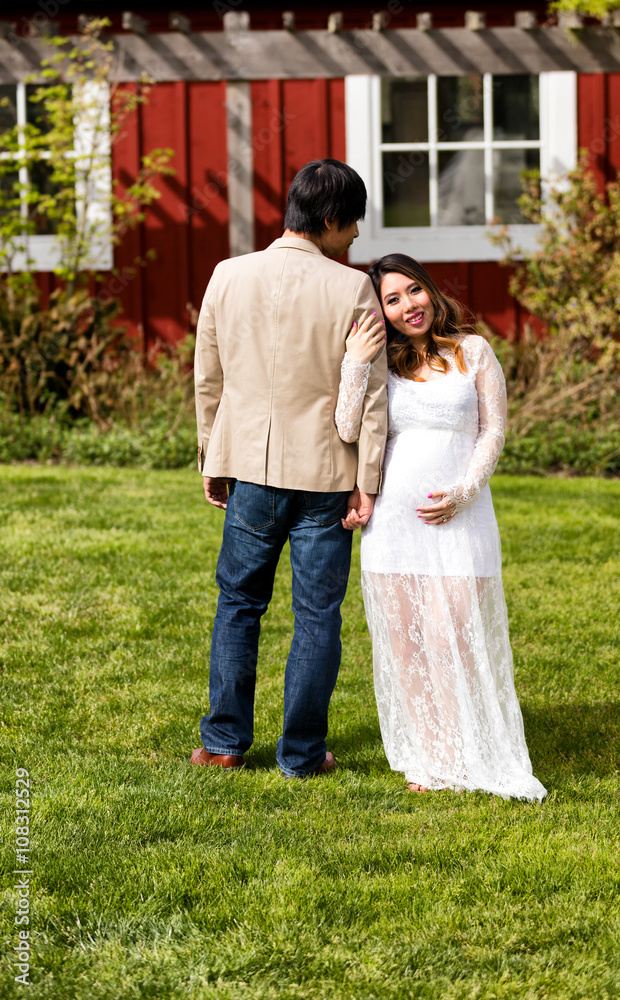 Fototapeta premium Expecting mom and dad standing next to each other while outdoors