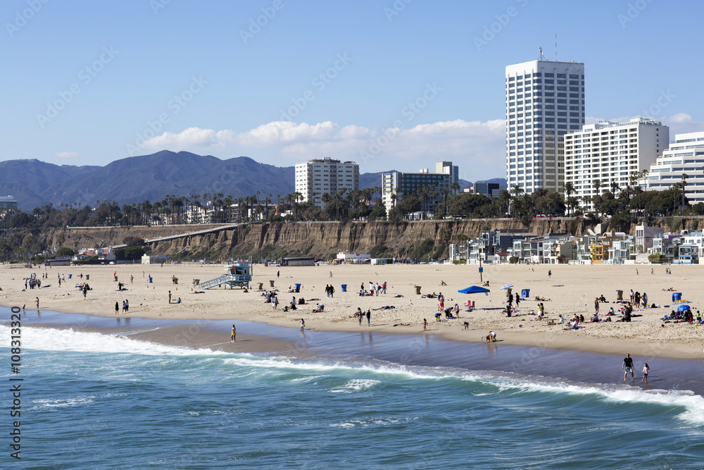 The Pacific ocean and a clear day, Santa Monica. Beach landscape in the USA with blue sea and mountain ranges. People relax on the beach. The Pacific ocean and a clear day, Santa Monica. Beach landscape in the USA with blue sea and mountain ranges. People relax on the beach.