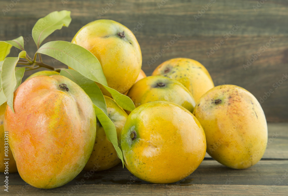 Mango tropical fruit on a wooden background Mango tropical fruit on a wooden background