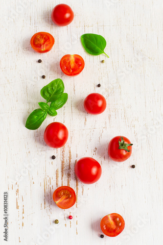 Cherry tomatoes with basil leaves on white Shabby background